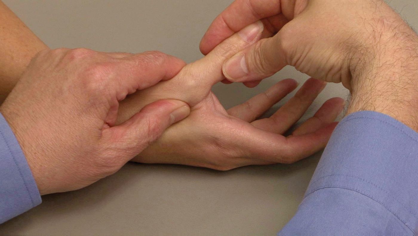 Doctor applying tension on thumb joint